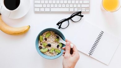 hand-holding-spoon-oatmeal-near-notebook_23-2148361712-3356124